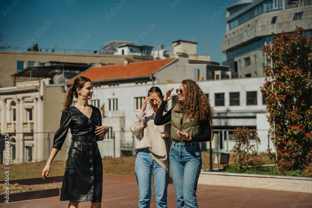 Stunning careless girls hanging out on a sunny day, having fun conversation and laughing