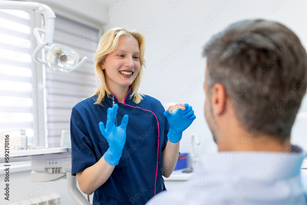 Dentist showing dental plaster mold to the patient. Dentist doctor showing jaw model at dental clinic, dental care concept. Dental care concept. Dentist showing dental plaster mold to the patient. Dentist doctor showing jaw model at dental clinic, dental care concept. Dental care concept.