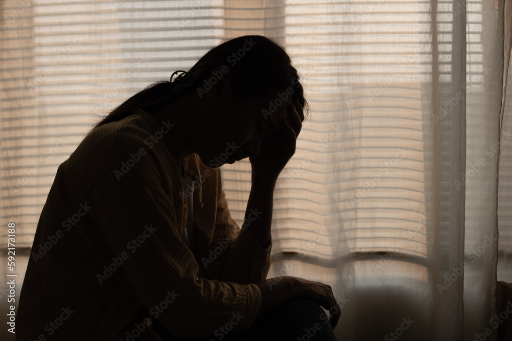 Female having depression sitting alone in bedroom dark corner. woman headache unhappy emotion. young anxiety despairing mental health problems. Dark Tone. Female having depression sitting alone in bedroom dark corner. woman headache unhappy emotion. young anxiety despairing mental health problems. Dark Tone.