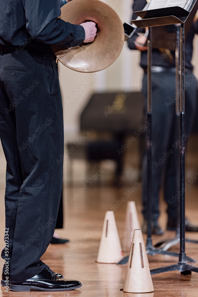 A wooden French horn mute next to a musicians feet during a performance