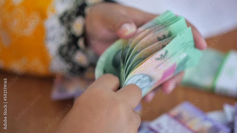 business woman counts money in hands. business woman counts rupiah in hands. Selective focus. business woman counts money in hands. business woman counts rupiah in hands. Selective focus.