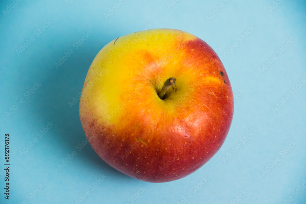 Juicy red yellow apple on a blue background. Concept of earth day, zero waste and plastic recycling. Juicy red yellow apple on a blue background. Concept of earth day, zero waste and plastic recycling.