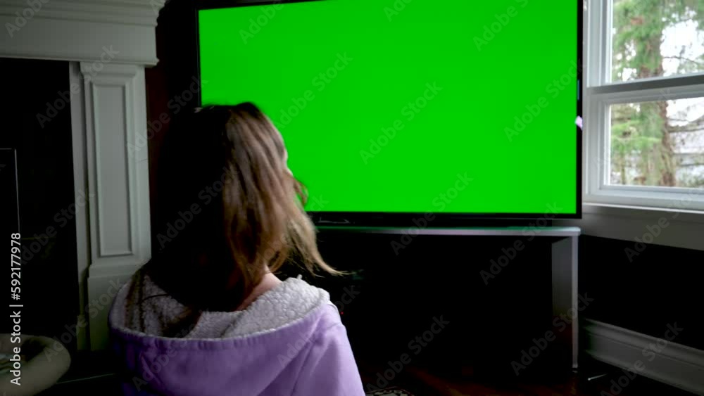 Back View of the Happily Married Black Couple Eating Popcorn on the Sofa and Watching TV with Green Screen Mock Up Display in Loft Living Room. Out of Focus Couple Close Up Shot Back View of the Happily Married Black Couple Eating Popcorn on the Sofa and Watching TV with Green Screen Mock Up Display in Loft Living Room. Out of Focus Couple Close Up Shot