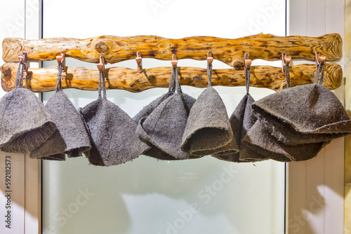 Banya and Bath House Ideas. Line of Banya and Spa Protective Hats Hanged on Hooks In front of banya or Spa