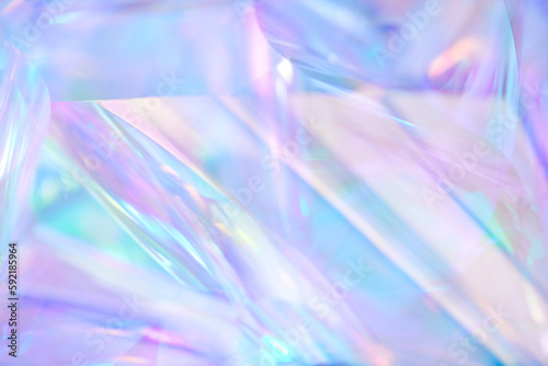 Fototapeta Naklejka Na Ścianę i Meble -  Close-up of ethereal pastel neon blue, purple, lavender, mint holographic metallic foil background. Abstract modern curved blurred surreal futuristic disco, rave, techno, festive dreamlike backdrop