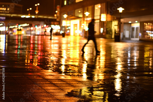 Man walks in the dark in the rain at the station forecourt in Essen, Germany
