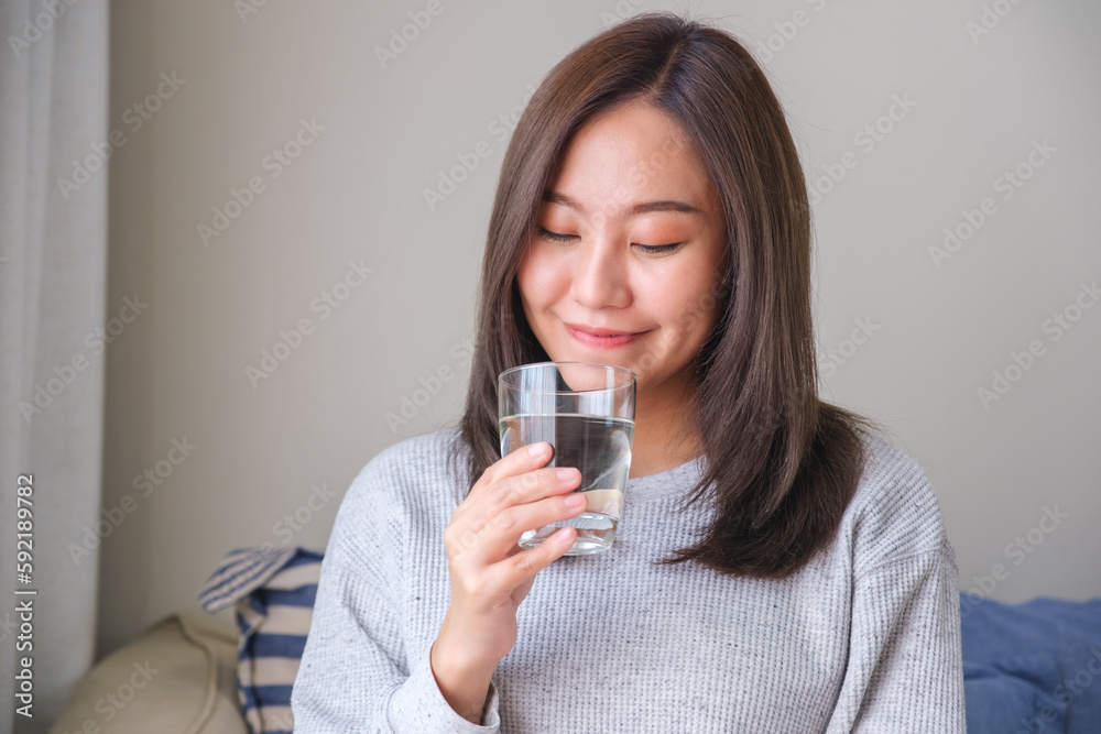 Portrait image of a young woman holding and drinking water Portrait image of a young woman holding and drinking water