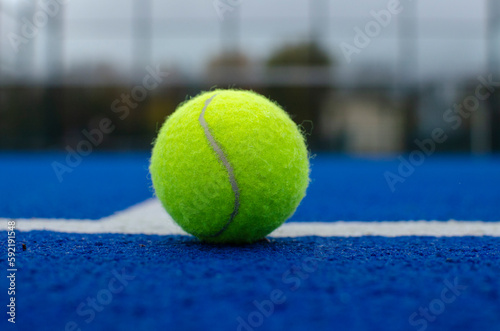 close-up view of a ball on the lines of a blue paddle tennis court, racket sports © Vic