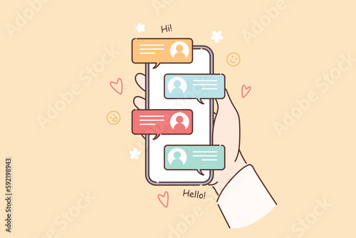 Mobile phone with messages in hands of person using social networks to correspond with friends