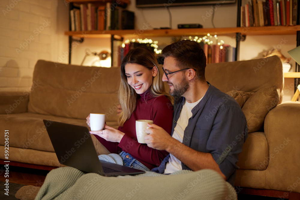 Young couple spending evening at home using laptop Young couple spending evening at home using laptop