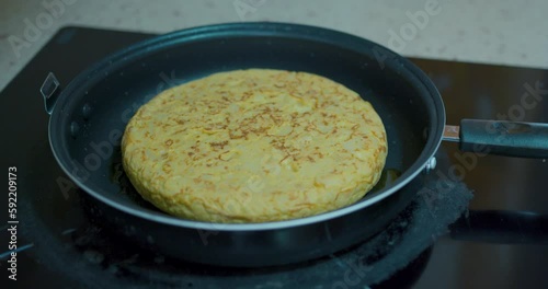 Wallpaper Mural moving a potato omelette cooking in a pan. Spanish food. Torontodigital.ca