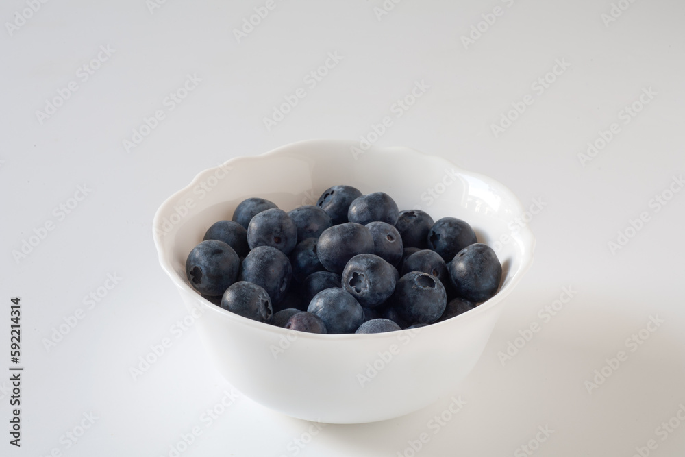 Blueberries are on the table in a white plate. On a white background. Blueberries are on the table in a white plate. On a white background.