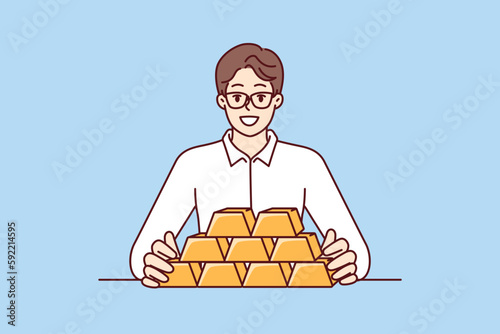 Businessman with gold bars sitting at table and smiling looking at camera for precious metals investment. Man investor with gold bars avoiding inflation and symbolizing diversification of assets