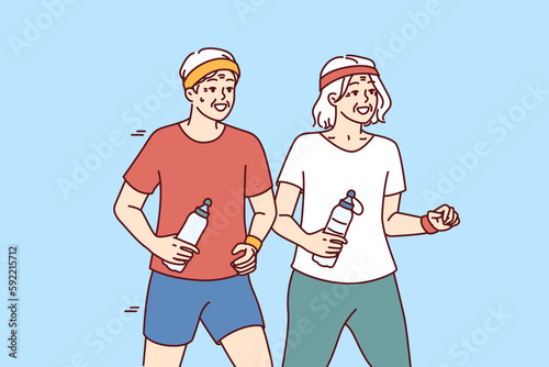 Elderly couple running and exercising outdoors having fun after retirement and enjoy active old age. Elderly men and women with water bottles do morning jog and lead healthy lifestyle