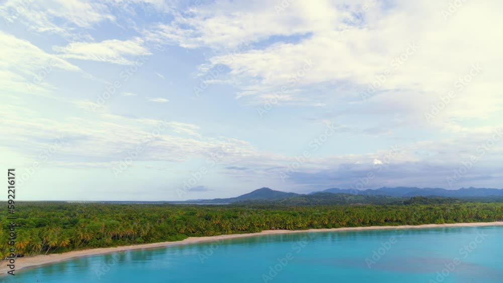 Panoramic image of a beautiful seascape with sandy beach and sea wave on a Dominican beach. Summer vacation on a tropical island with beautiful palm jungle. Morning wildlife landscape, aerial view. Panoramic image of a beautiful seascape with sandy beach and sea wave on a Dominican beach. Summer vacation on a tropical island with beautiful palm jungle. Morning wildlife landscape, aerial view.