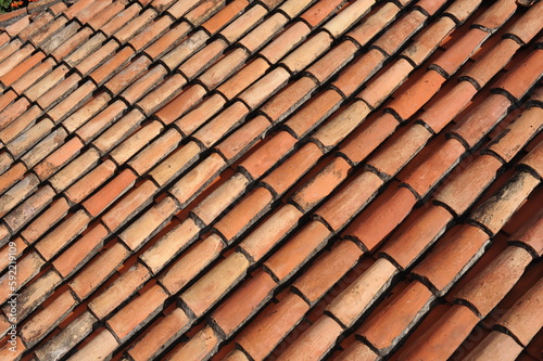 Red and orange roof tiles texture pattern on roof of an old historical building