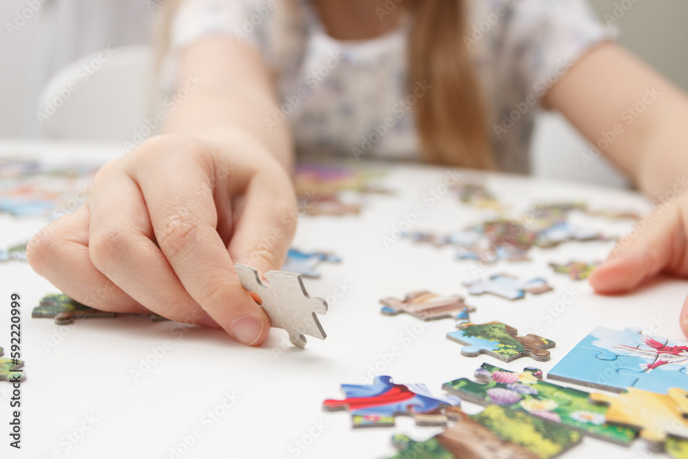 Little child picks up picture from pieces of puzzles Little child picks up picture from pieces of puzzles