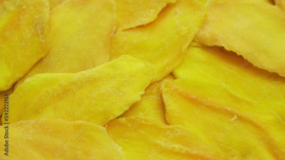 Mango Dried Slices Rotation Close-up. Yellow Abstract Background of Mango Slices. Ripe Mango, Fruits, Healthy Vegetarian Food. Mango Dried Slices Rotation Close-up. Yellow Abstract Background of Mango Slices. Ripe Mango, Fruits, Healthy Vegetarian Food.