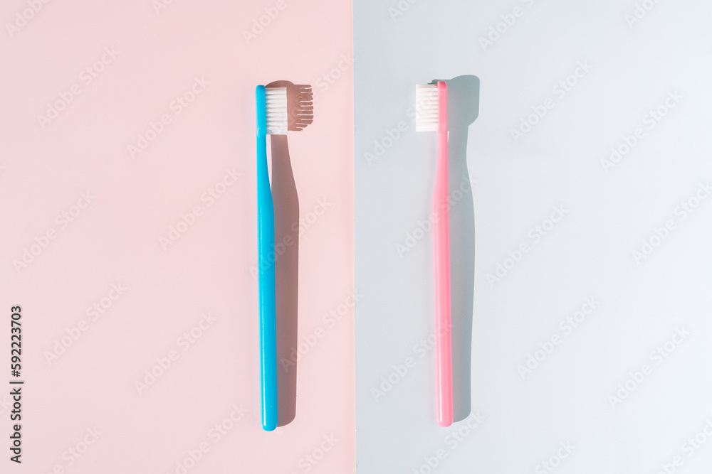Blue and pink toothbrush on pink and blue background under hard light. Blue and pink toothbrush on pink and blue background under hard light.