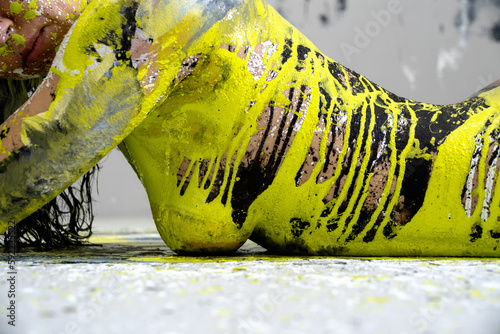 Foto side view of upper body of young sexy naked woman in black, white and light green paint color painted, lies decorative, elegant on the Studio floor
