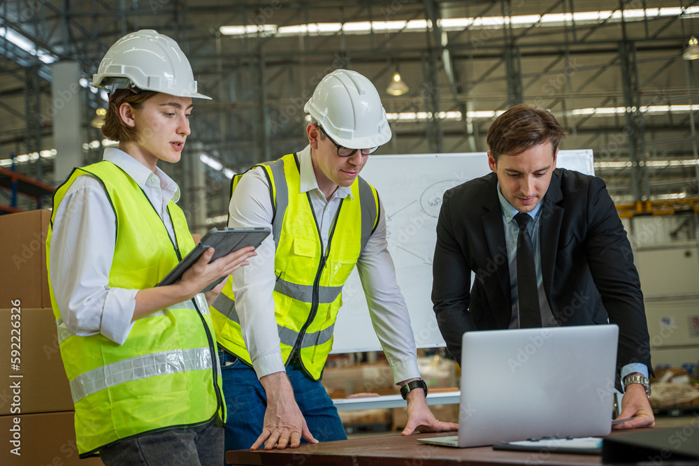 Warehouse manager meeting with his team in a large distribution warehouse. Warehouse manager meeting with his team in a large distribution warehouse.