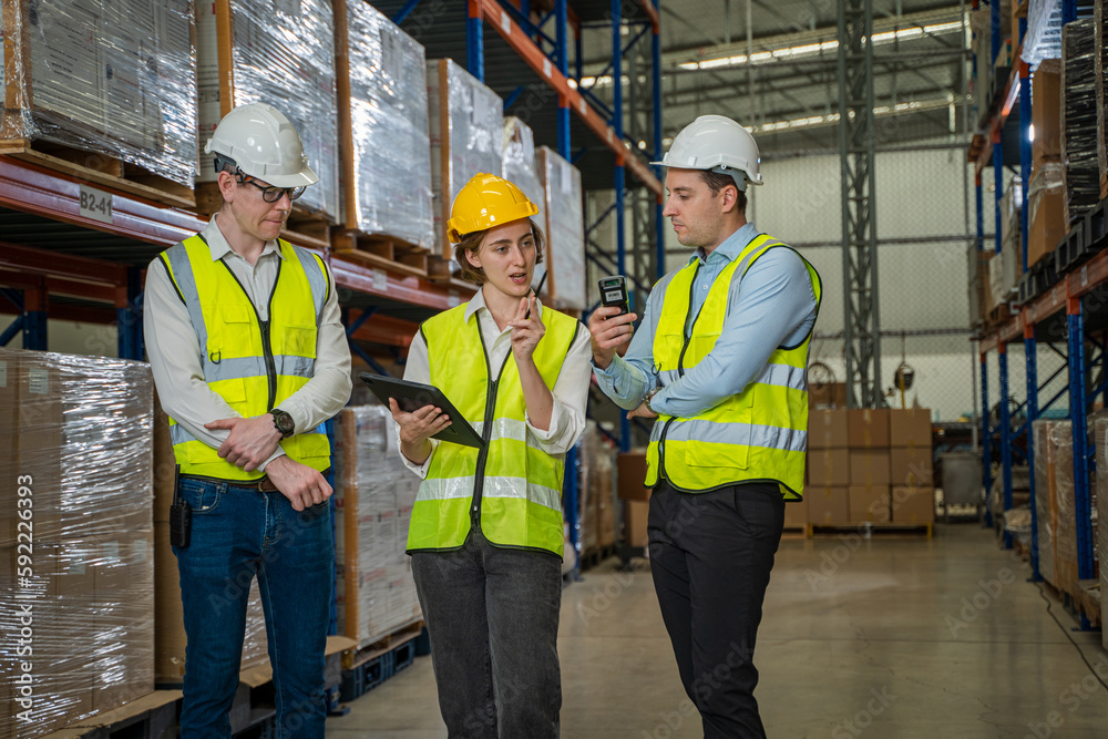 Managers visit warehouse,Manager uses digital tablet for checking stock in a large distribution warehouse. Managers visit warehouse,Manager uses digital tablet for checking stock in a large distribution warehouse.