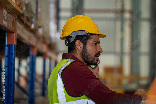 Warehouse employees uses digital tablet computer with Inventory checking software in the retail warehouse full of shelves with goods,Distribution Center.