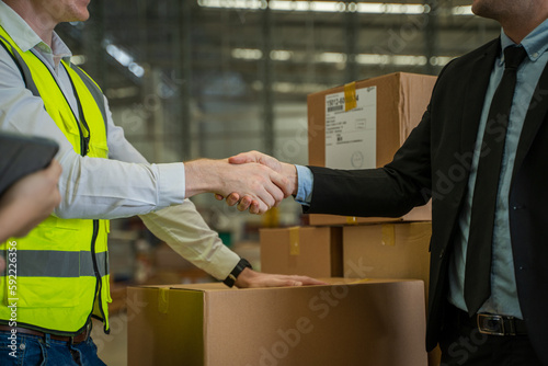 Warehouse manager meeting with his team in a large distribution warehouse.