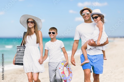 Happy young family having fun in vacation on beach