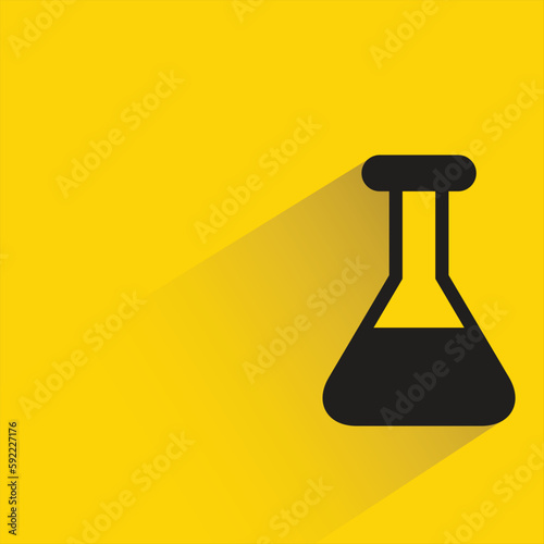 lab flask with shadow on yellow background