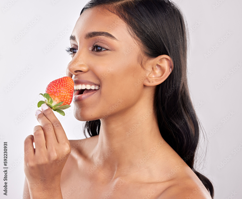 Happy, healthy and a woman eating a strawberry for nutrition isolated on a white background in a studio. Smile, thinking and an Indian girl with a fruit for a diet, breakfast or vitamins from food Happy, healthy and a woman eating a strawberry for nutrition isolated on a white background in a studio. Smile, thinking and an Indian girl with a fruit for a diet, breakfast or vitamins from food