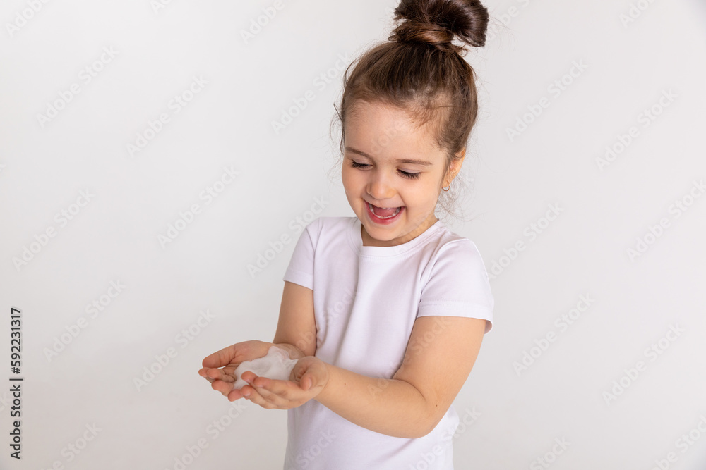 Clean and protection from infection by a little girl washing her hands with foam soap in the bathroom for virus prevention. A child practicing hygiene and cleanliness by rinsing her palms in the sink Clean and protection from infection by a little girl washing her hands with foam soap in the bathroom for virus prevention. A child practicing hygiene and cleanliness by rinsing her palms in the sink