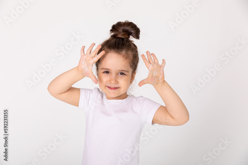 funny and joyful baby shows his soapy palms. Copy-space. Prevention of diseases with viruses and flu. The exposure time of the soap is at least 20 seconds. Studio photo, banner, isolated.