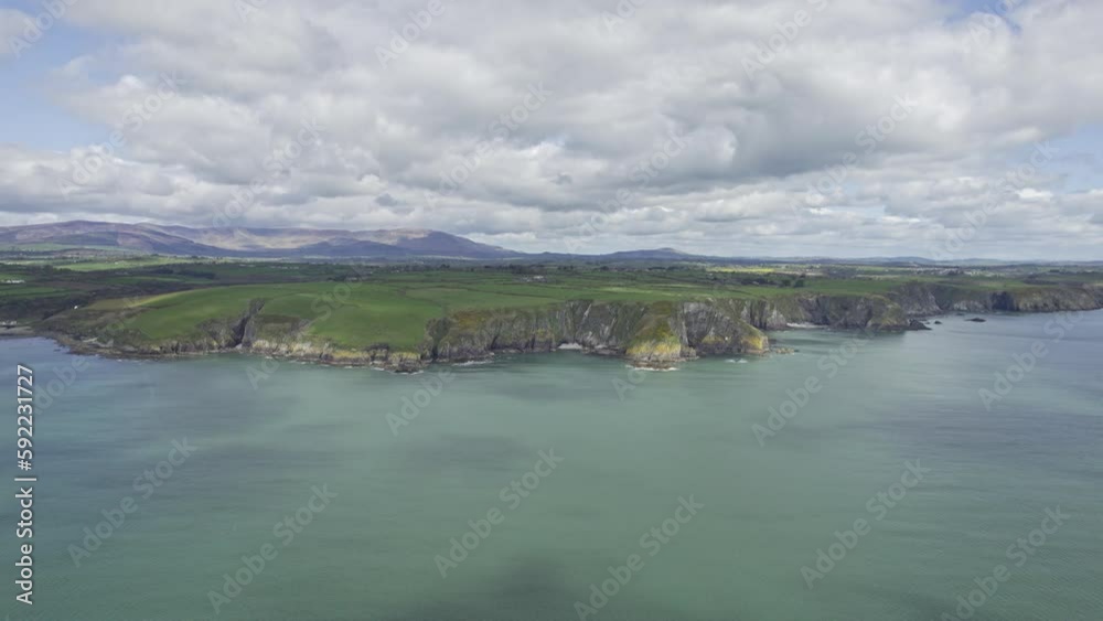 Slow panning shot left of the Waterford Copper Coast with the mvagestic Comeragh Mountain Range in the background on a bright spring day Ireland at its best Slow panning shot left of the Waterford Copper Coast with the mvagestic Comeragh Mountain Range in the background on a bright spring day Ireland at its best