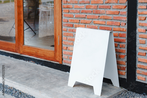 Empty white frame stand on cement floor with red brick vintage wall loft style. Blank advertising template. Creative art concept , space for text marketing promotion.
