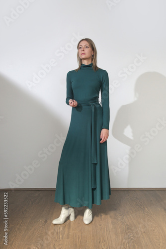 Serie of studio photos of young female model wearing maxi green cotton dress with long sleeves
