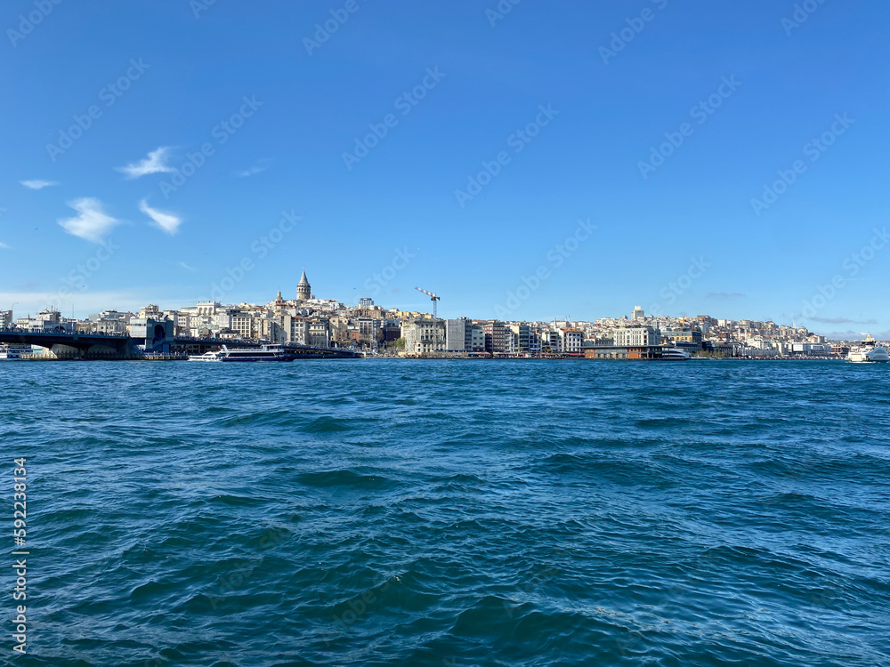 Galata tower view from Eminonu district with City lines ferry crossing the Galata bridge. Istanbul Turkey