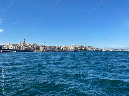 Galata tower view from Karakoy district with City lines ferry crossing the Galata bridge. © Arda ALTAY