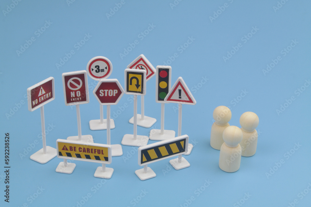 Many road signs and three people figures. Study traffic rules and driving school concept.