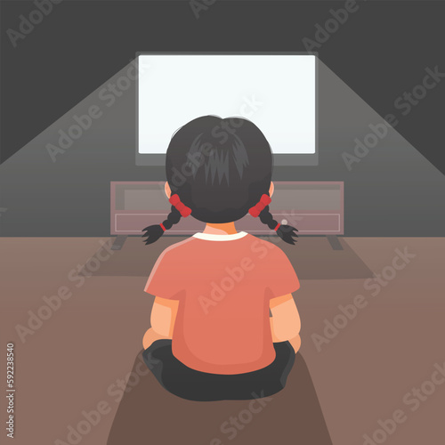 Cute little girl watching TV in the dark room on the floor