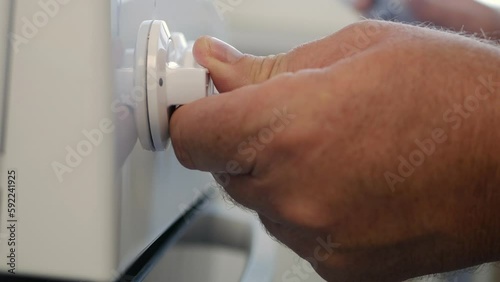 A Man Lighting Up Fire at Gas Cooker with a Lighter. Close-up shooting with a hand firing a Burner in the Kitchen.
