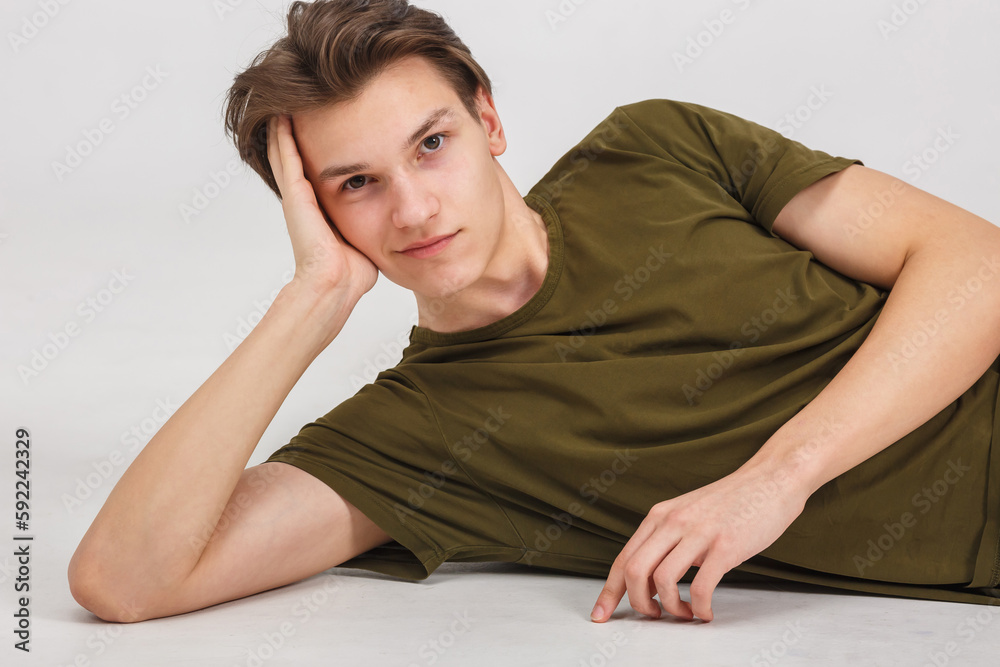 fashion glamorous portrait of handsome boy is posing lying on white background in studio fashion glamorous portrait of handsome boy is posing lying on white background in studio