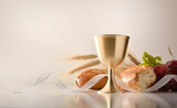 Chalice on table with bread and grapes in the background
