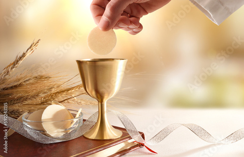 Priest dipping host in wine at Eucharist
