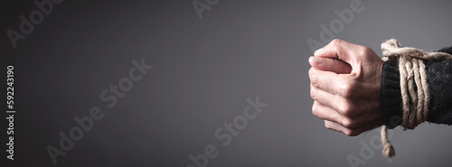 Photos Hands tied with a rope. Concept of imprisonment