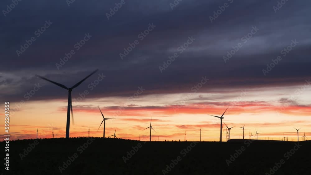 Beautiful view of wind turbines in a field during sunset Beautiful view of wind turbines in a field during sunset
