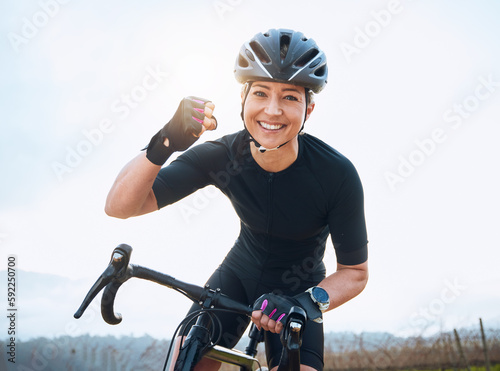 Fototapeta Naklejka Na Ścianę i Meble -  Fitness, celebration and portrait of woman cycling with power fist, success or victory in the countryside. Happy, sports and face of lady cyclist celebrating workout achievement, milestone or winning
