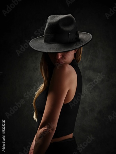 Caucasian girl from Croatia in a hat on black background