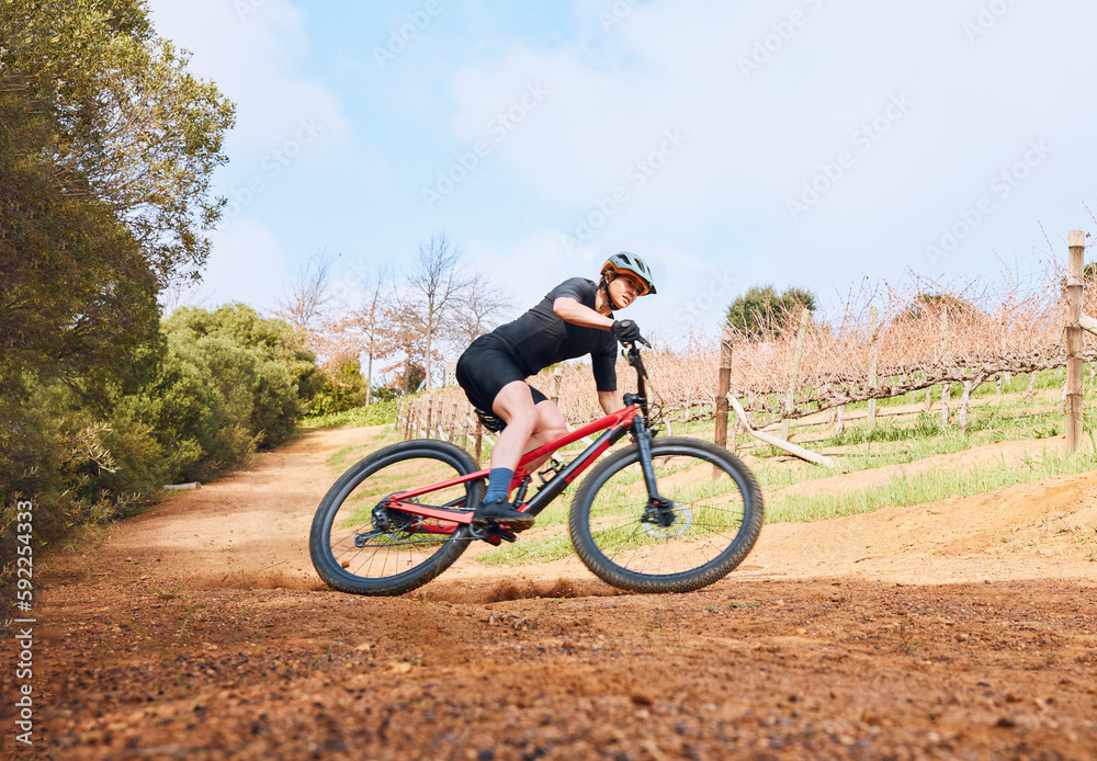 Bicycle, ride outdoor and fitness woman on a bike with speed for sports race on a nature dirt road. Exercise, fast and athlete doing sport training on countryside trail for cardio and cycling workout