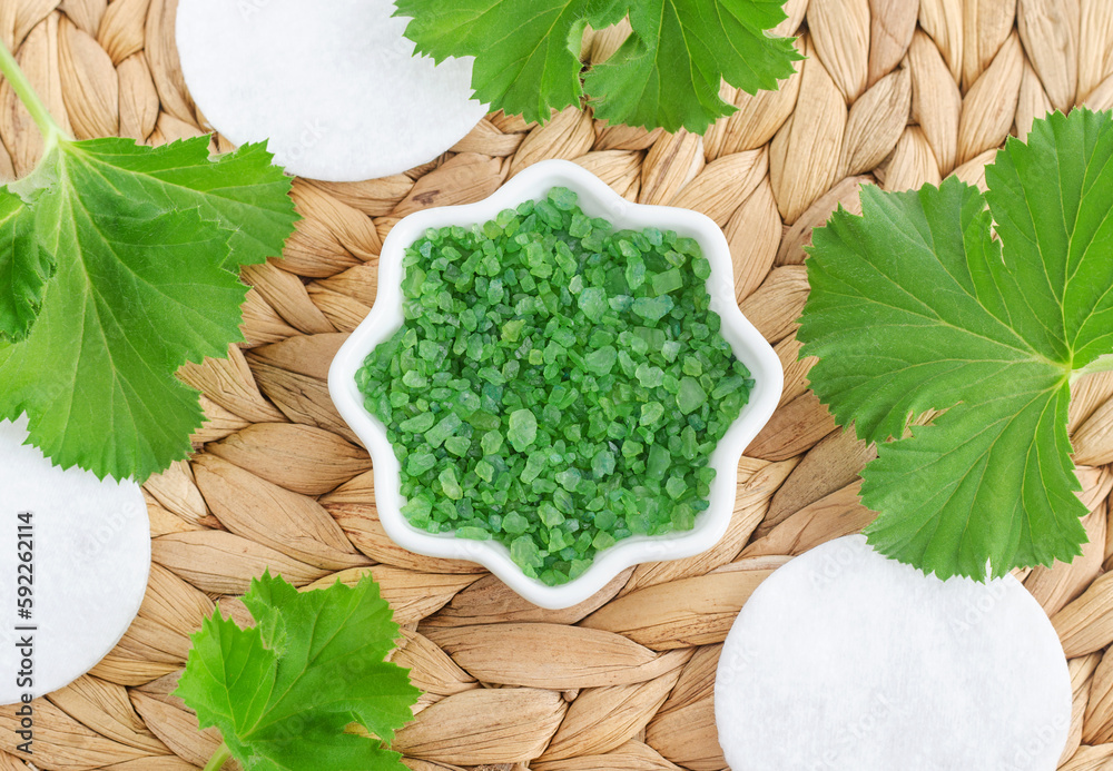 Small porcelain bowl with green herbal bath salt (foot soak), cotton pads and pelargonia leaves. Homemade spa and beauty recipe. Small porcelain bowl with green herbal bath salt (foot soak), cotton pads and pelargonia leaves. Homemade spa and beauty recipe.